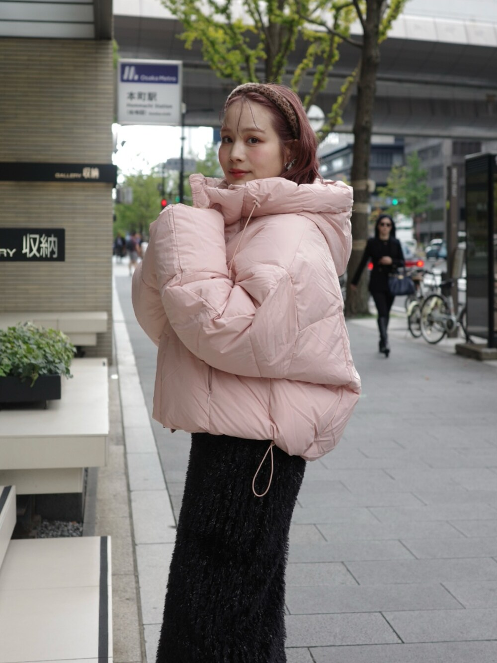 ブラック系のスカート、ピンク系のダウンジャケット/コート、ブラック系のブーツを着用したレディースの冬コーディネートの3枚目の写真