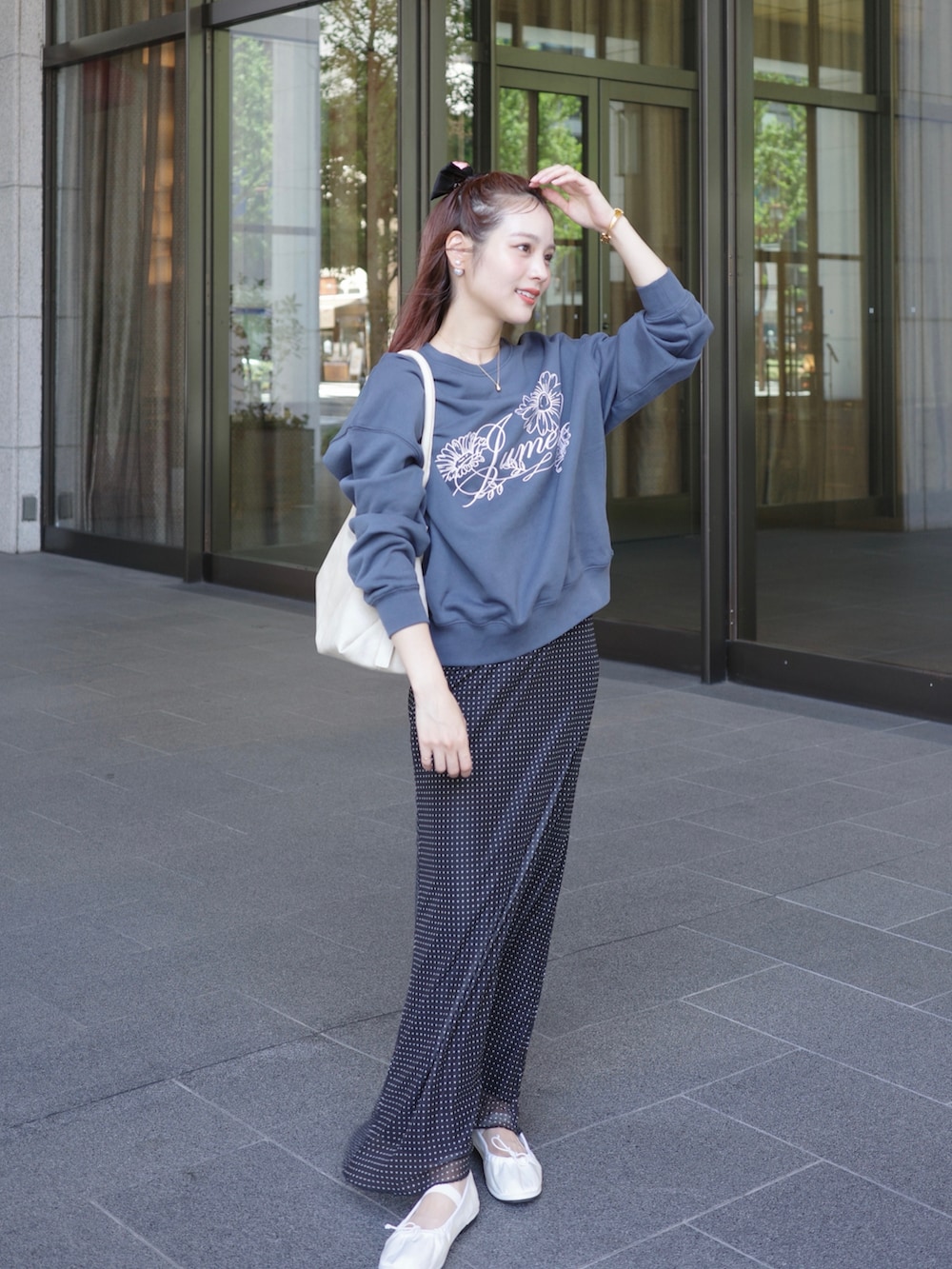 ブルー系のスウェット、ブラック系のスカート、ホワイト系のバレエシューズを着用したレディースの秋コーディネートの2枚目の写真