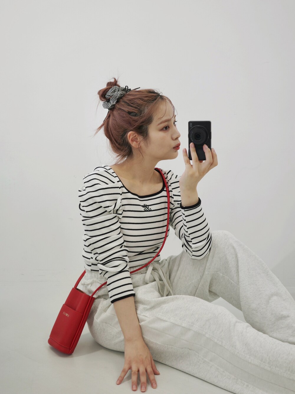 ベージュ系のサンダル、ホワイト系のスウェットパンツ、レッド系のショルダーバッグを着用したレディースの秋コーディネートの3枚目の写真