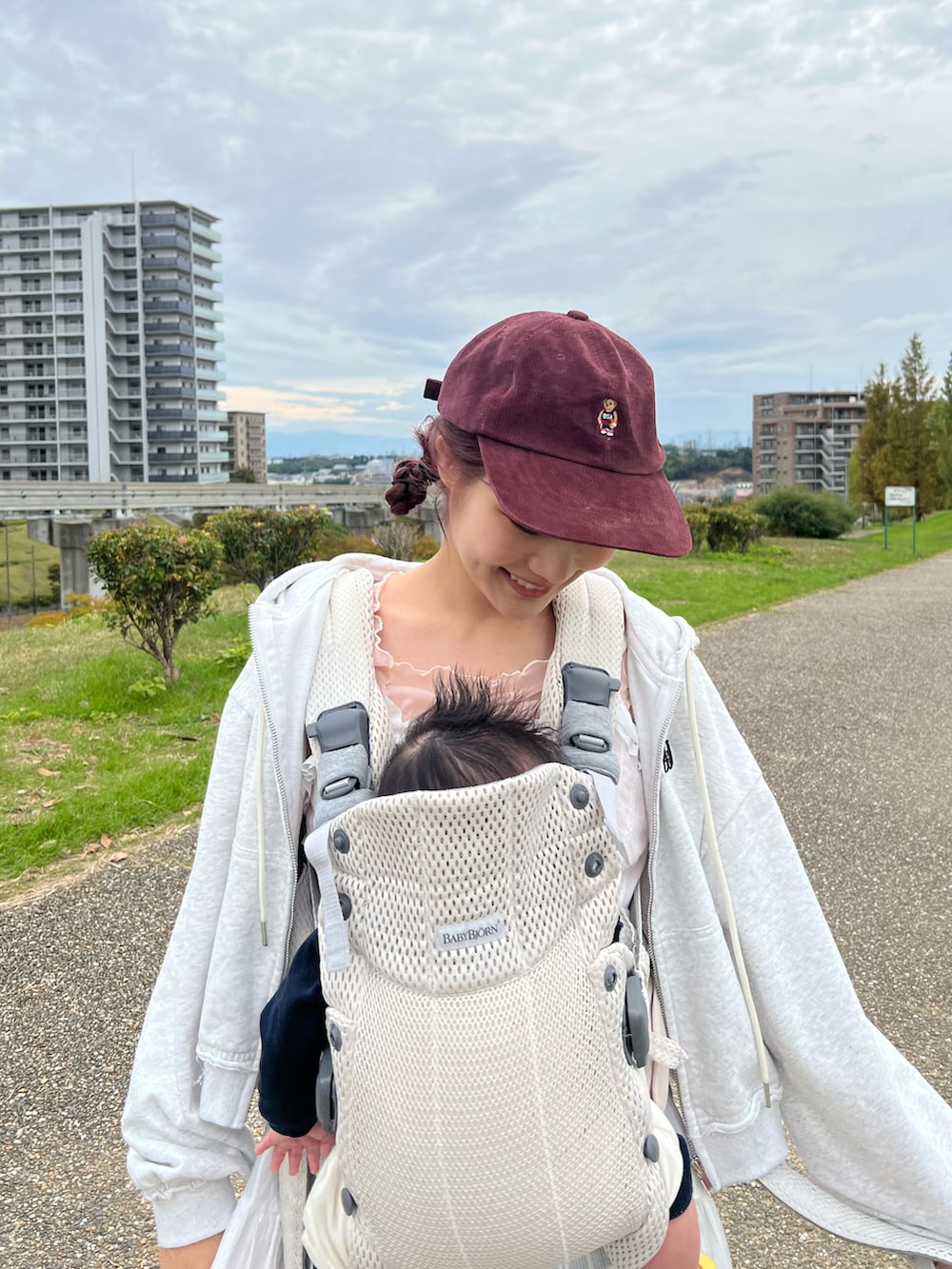 ブラック系のスラックス、ベージュ系のブーツ、ホワイト系のパーカーを着用したレディースの秋コーディネートの2枚目の写真