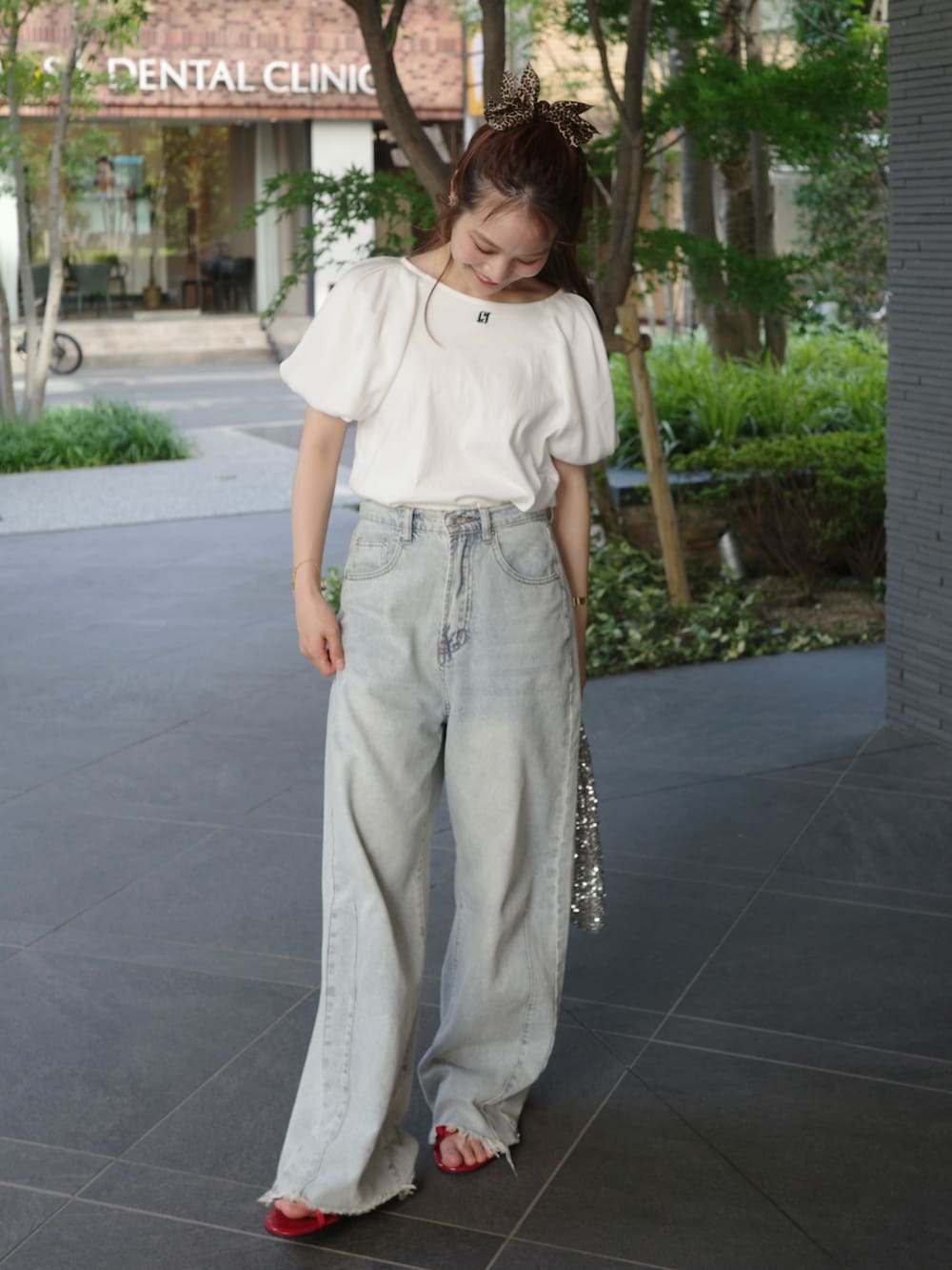 ホワイト系のTシャツ/カットソー、ブルー系のデニムパンツ、ブラウン系のバレッタ/ヘアクリップを着用したレディースの夏コーディネートの2枚目の写真