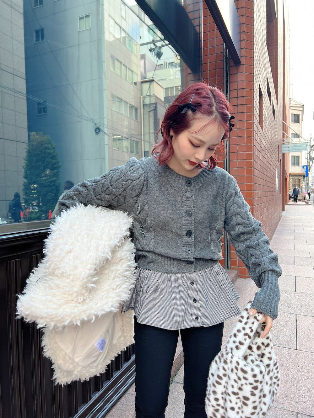 グレー系のニット/セーター、ブラック系のデニムパンツ、ブラウン系のパンプスを着用したレディースの冬コーディネートの2枚目の写真