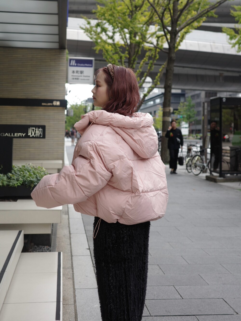 ブラック系のスカート、ピンク系のダウンジャケット/コート、ブラック系のブーツを着用したレディースの冬コーディネートの2枚目の写真