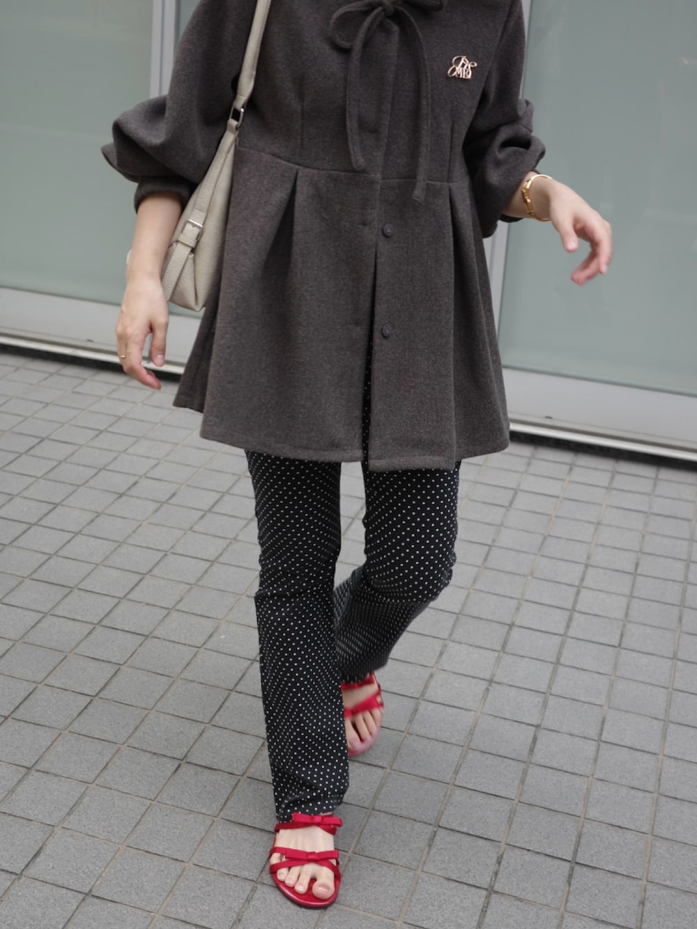 グレー系のその他アウター、ブラック系のその他パンツ、レッド系のサンダルを着用したレディースの秋コーディネートの2枚目の写真