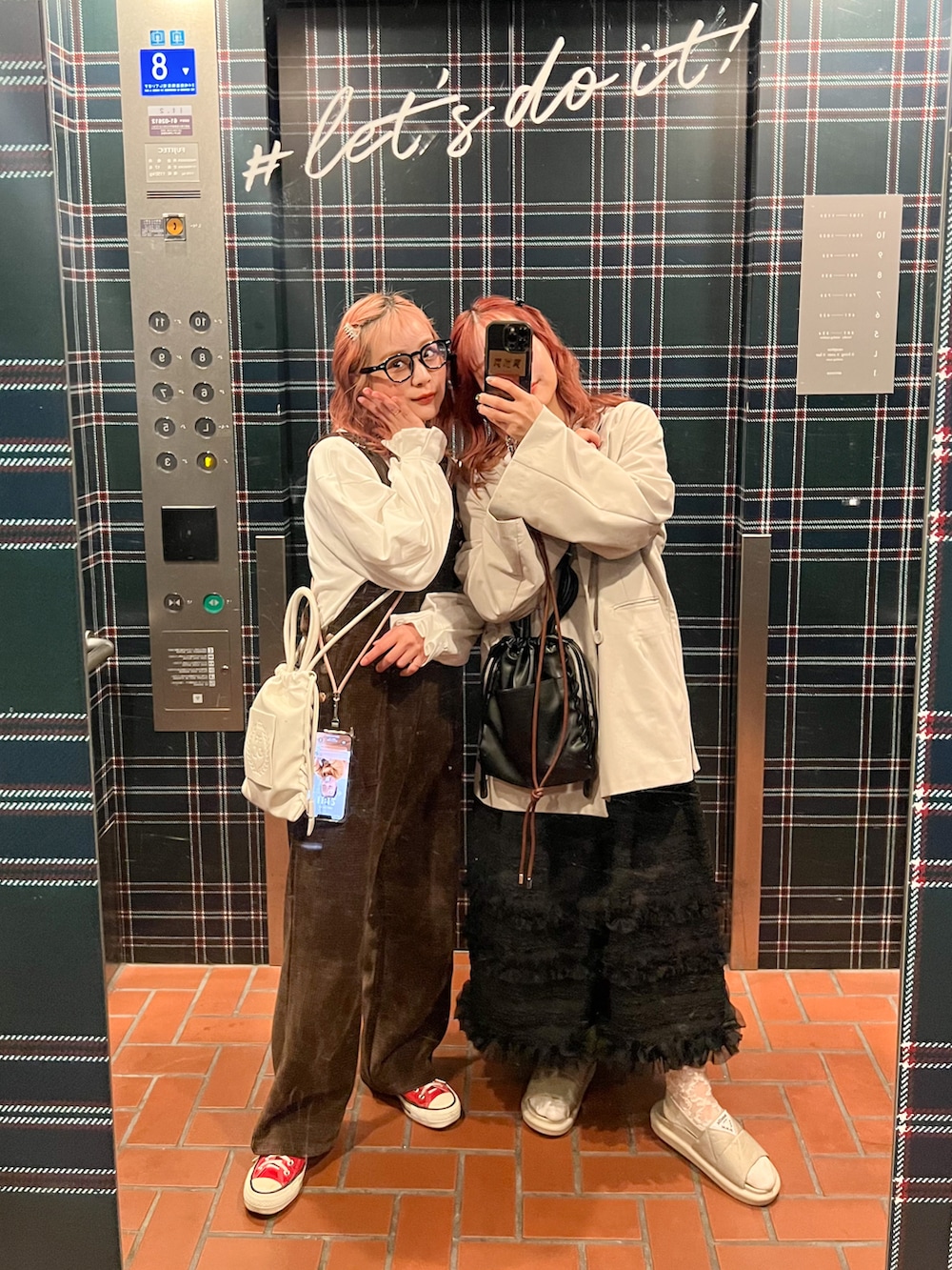 ブラウン系のサロペット/オーバーオール、ホワイト系のTシャツ/カットソー、レッド系のスニーカーを着用したレディースの春コーディネートの2枚目の写真