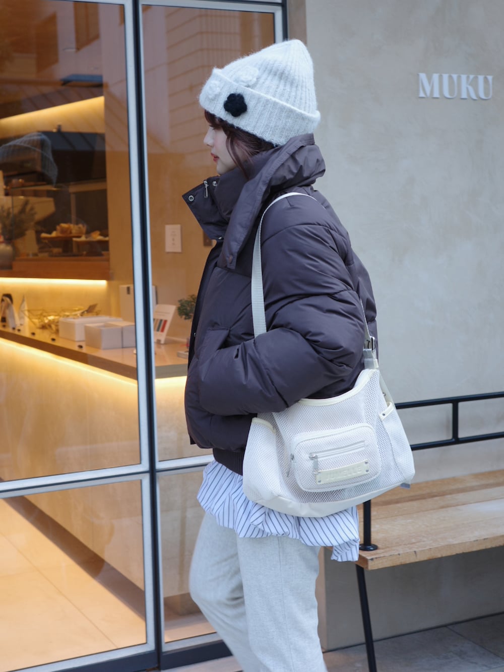 ブラウン系のその他アウター、グレー系のその他パンツ、ホワイト系のニットキャップ/ビーニーを着用したレディースの冬コーディネートの2枚目の写真