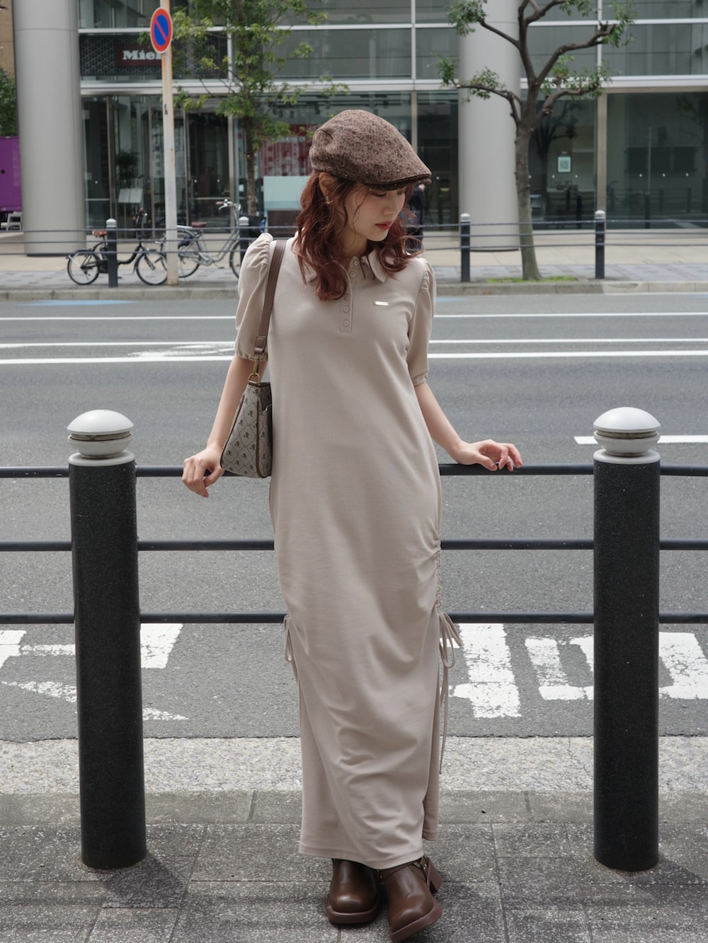 ベージュ系のワンピース、ブラウン系のショルダーバッグ、ブラウン系のハンチング/ベレー帽を着用したレディースの春コーディネートの2枚目の写真