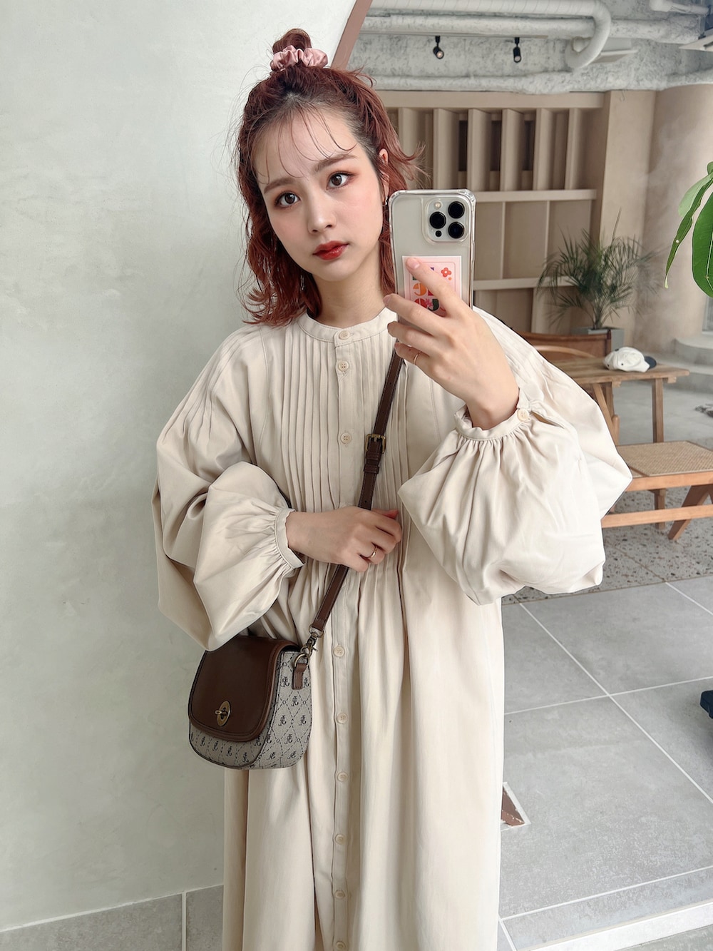 ベージュ系のワンピース、ホワイト系のブーツ、その他のショルダーバッグを着用したレディースの冬コーディネートの2枚目の写真