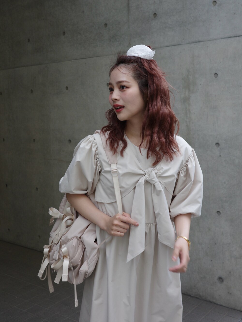 ベージュ系のワンピース、ホワイト系のスニーカー、ベージュ系のバックパック/リュックを着用したレディースの春コーディネートの3枚目の写真