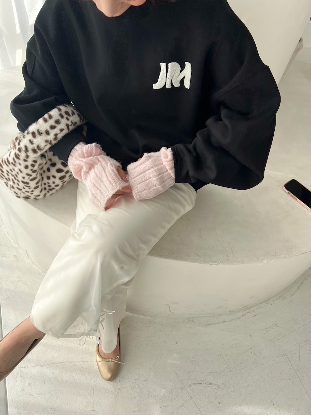 ブラック系のスウェット、ホワイト系のその他パンツ、ゴールド系のバレエシューズを着用したレディースの冬コーディネートの2枚目の写真