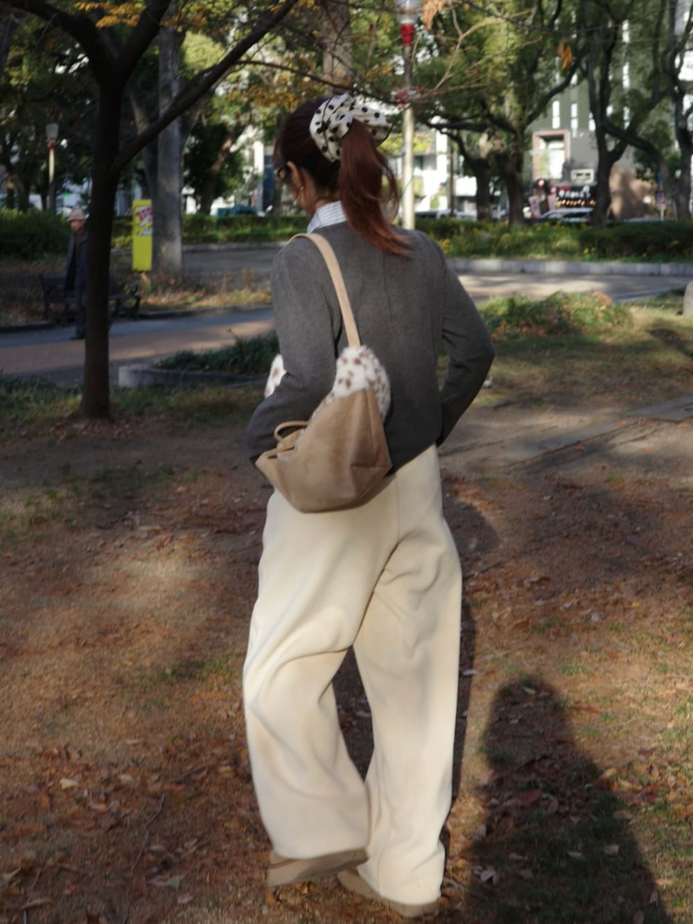 イエロー系のスウェットパンツ、ベージュ系のショルダーバッグ、ブラウン系のメガネを着用したレディースの冬コーディネートの2枚目の写真