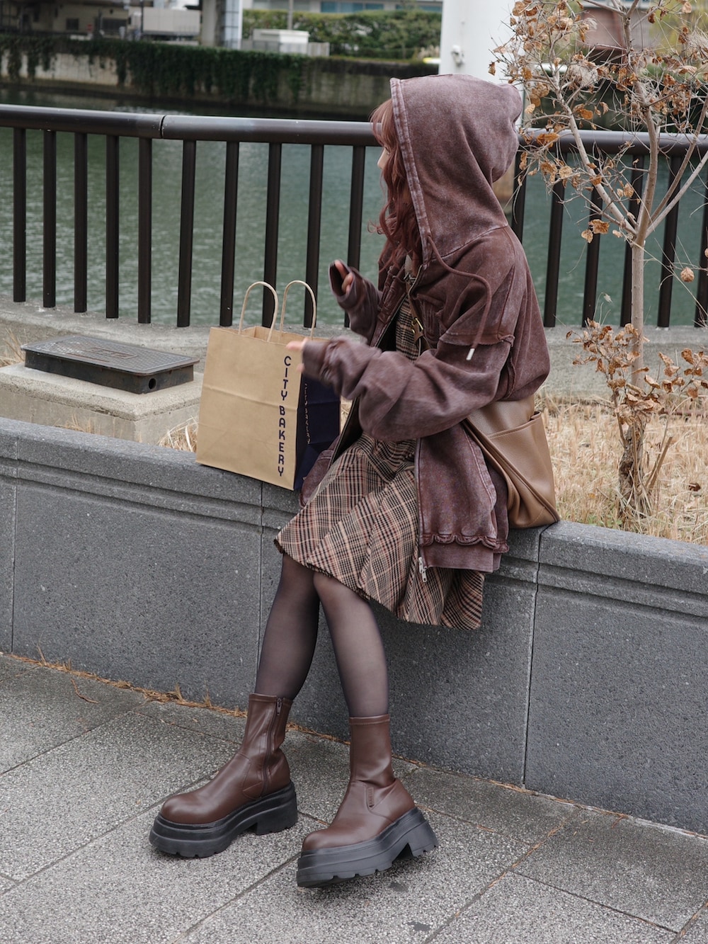 ブラウン系のワンピース、ブラウン系のパーカー、ブラウン系のショルダーバッグを着用したレディースの冬コーディネートの2枚目の写真