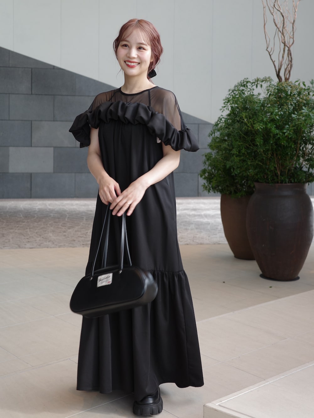 ブラック系のワンピース、ブラック系のショルダーバッグ、ブラック系のローファーを着用したレディースの冬コーディネートの2枚目の写真