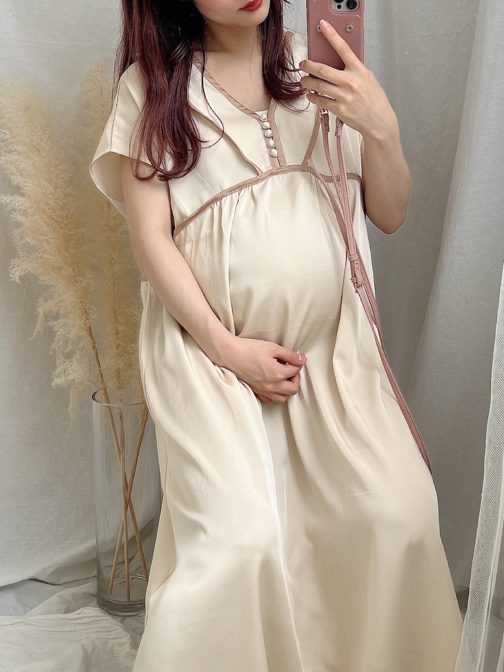 ベージュ系のワンピース、ブラウン系のスマホケース/カバーを着用したレディースの夏コーディネートの2枚目の写真