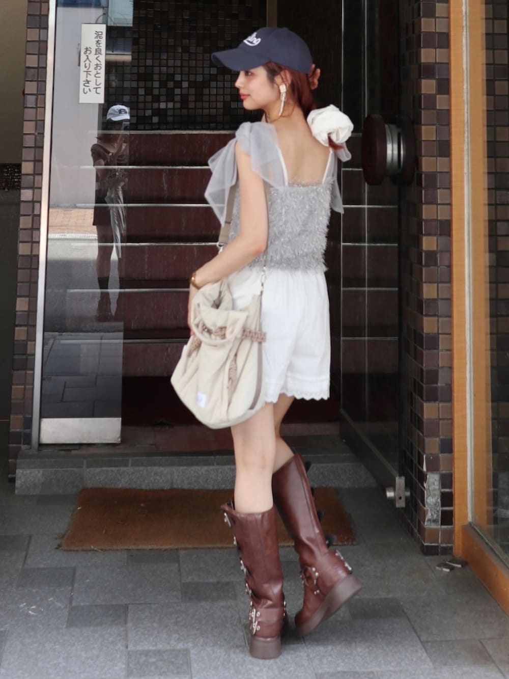 ブラウン系のブーツ、ベージュ系のショルダーバッグ、ホワイト系のその他パンツを着用したレディースの夏コーディネートの2枚目の写真