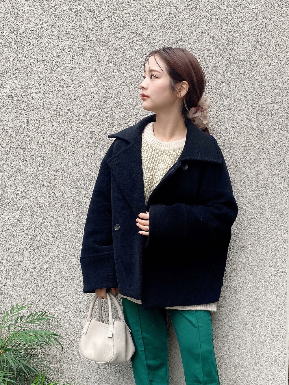 ベージュ系のニット/セーター、グリーン系のその他パンツ、ベージュ系のハンドバッグを着用したレディースの冬コーディネートの2枚目の写真