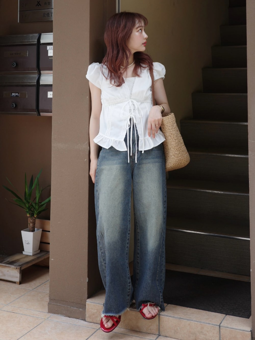 グリーン系のデニムパンツ、レッド系のサンダル、ブラウン系のトートバッグを着用したレディースの夏コーディネートの2枚目の写真