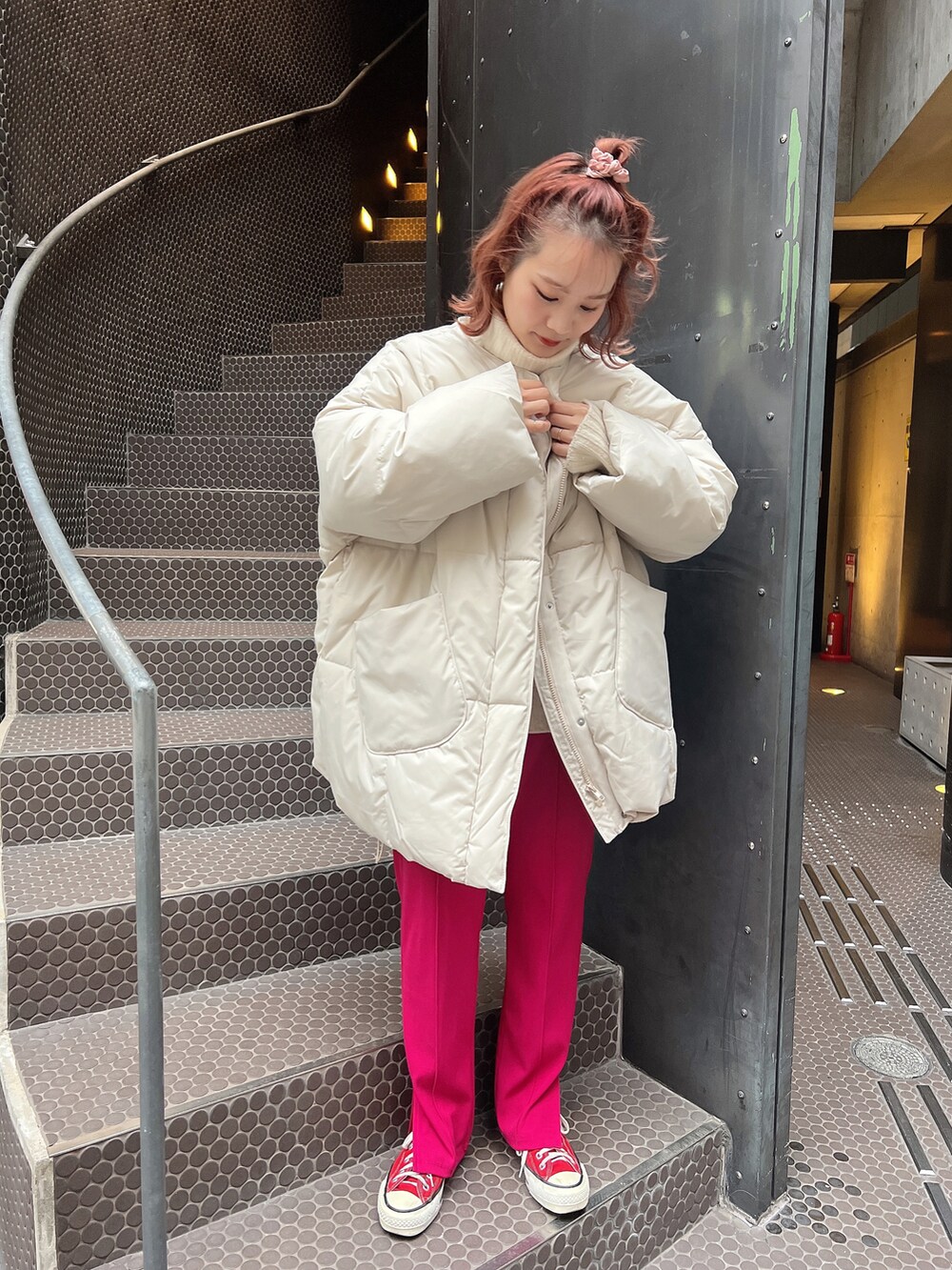 ホワイト系のニット/セーター、ピンク系のスラックス、レッド系のスニーカーを着用したレディースの冬コーディネートの2枚目の写真