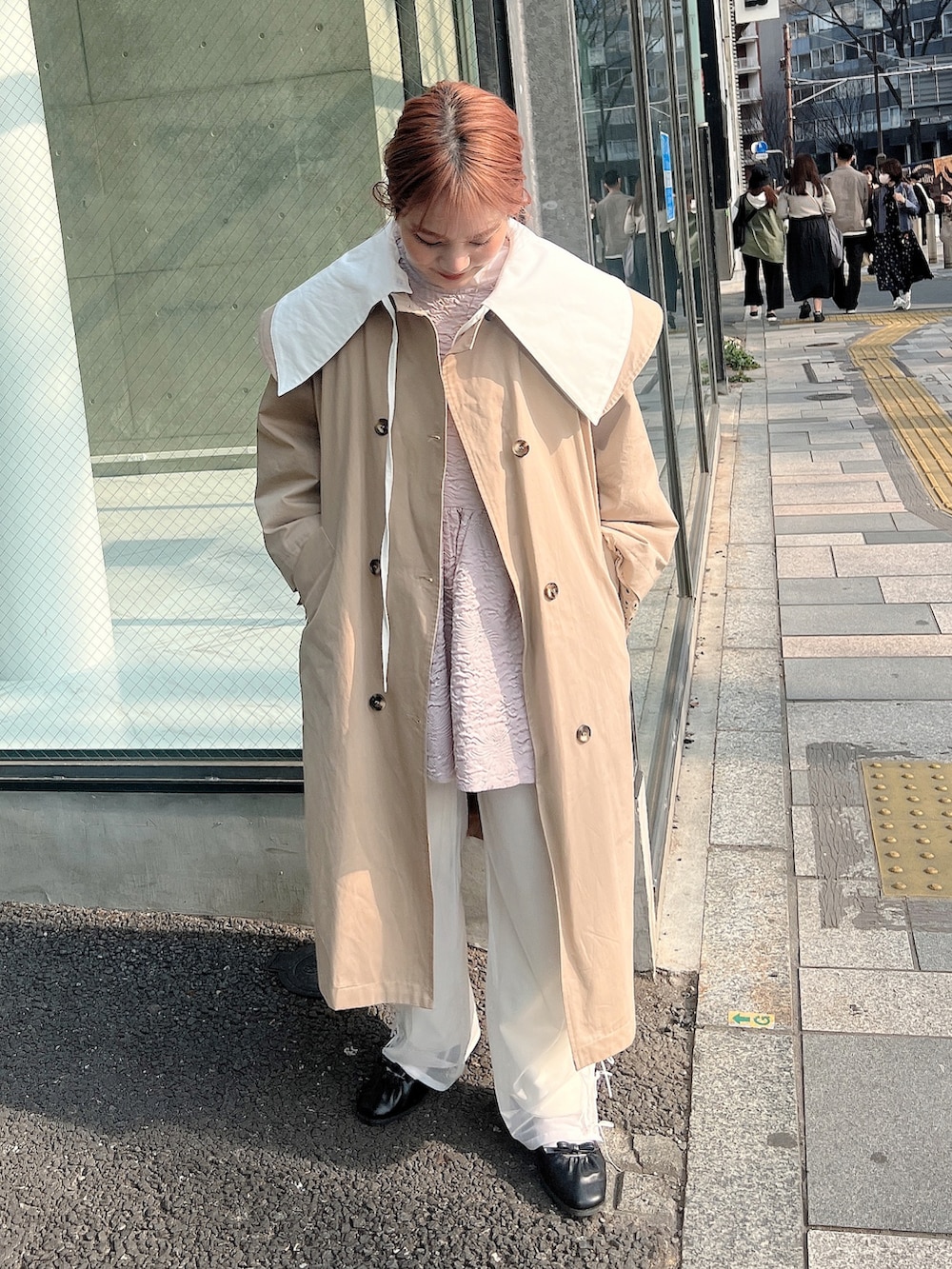 ブラウン系のトートバッグ、ベージュ系のトレンチコート、ブラック系のサンダルを着用したレディースの春コーディネートの2枚目の写真