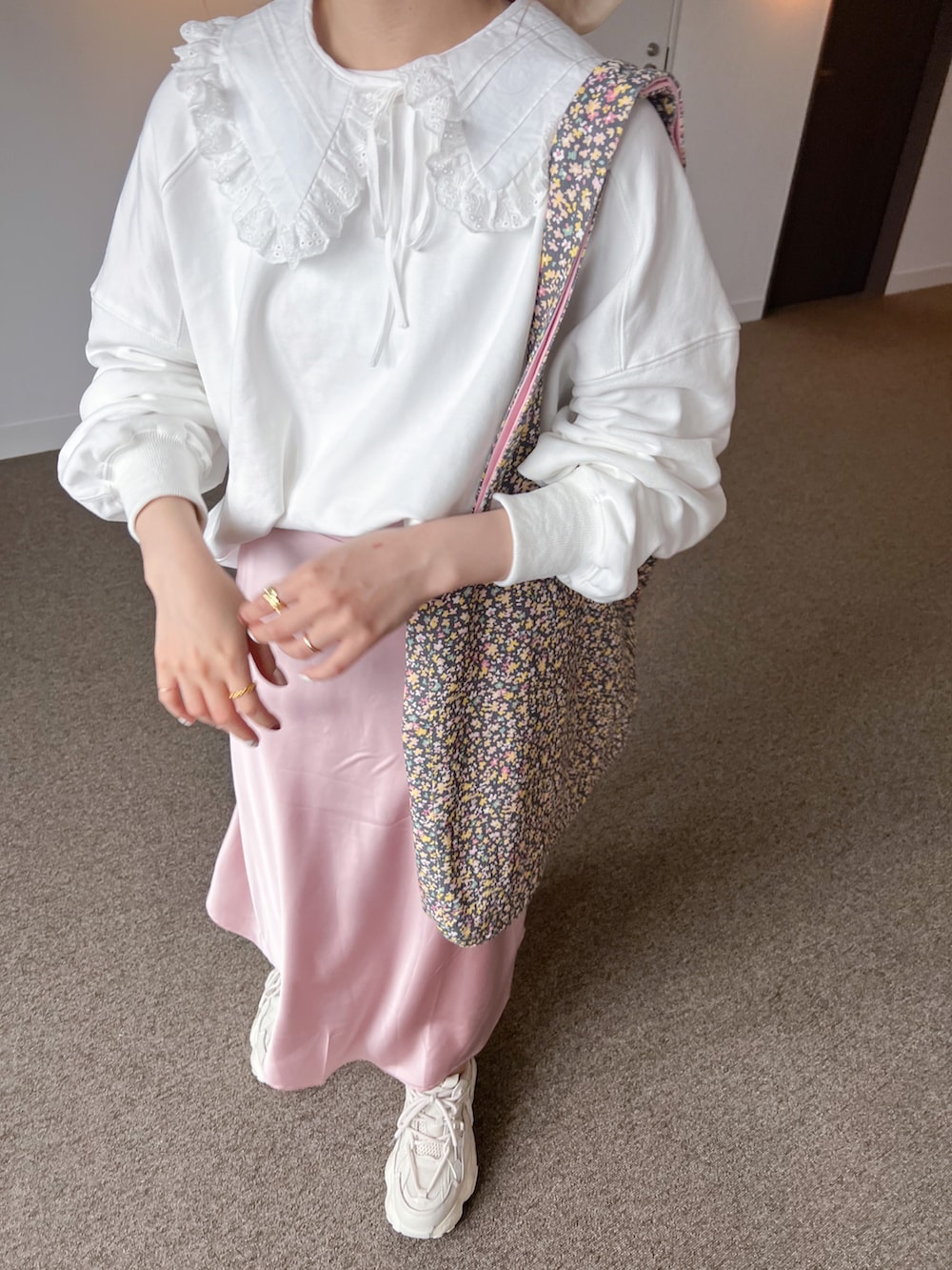 ホワイト系のスウェット、ピンク系のスカート、ベージュ系のスニーカーを着用したレディースの春コーディネートの2枚目の写真