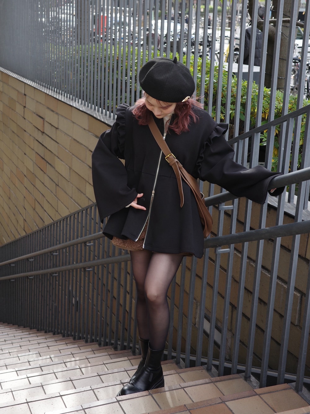 ブラック系のスウェット、ホワイト系のニット/セーター、ブラック系のブーツを着用したレディースの冬コーディネートの2枚目の写真