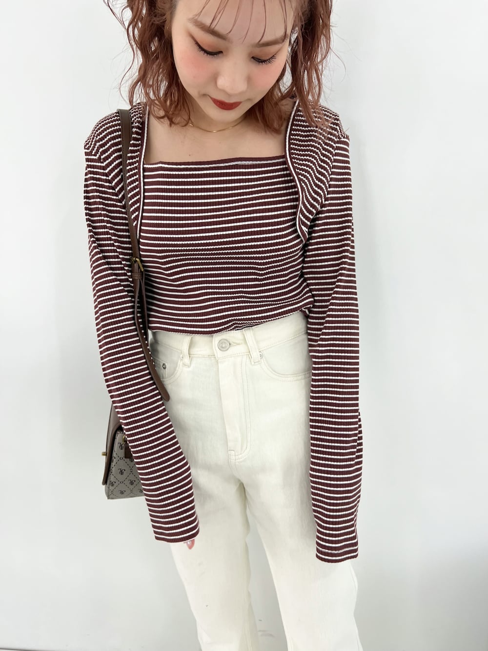 ブラウン系のTシャツ/カットソー、ホワイト系のパンツ、ブラック系のバレエシューズを着用したレディースの冬コーディネートの2枚目の写真