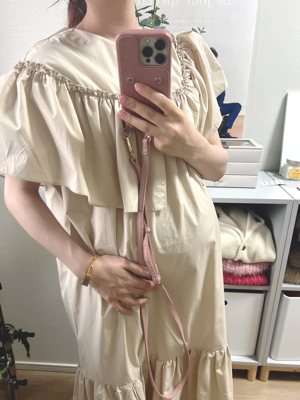 ベージュ系のワンピース、ブラウン系のスマホケース/カバーを着用したレディースの夏コーディネートの2枚目の写真