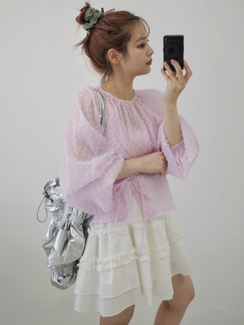 ピンク系のシャツ/ブラウス、シルバー系のショルダーバッグ、ブラウン系のブーツを着用したレディースの秋コーディネートの2枚目の写真