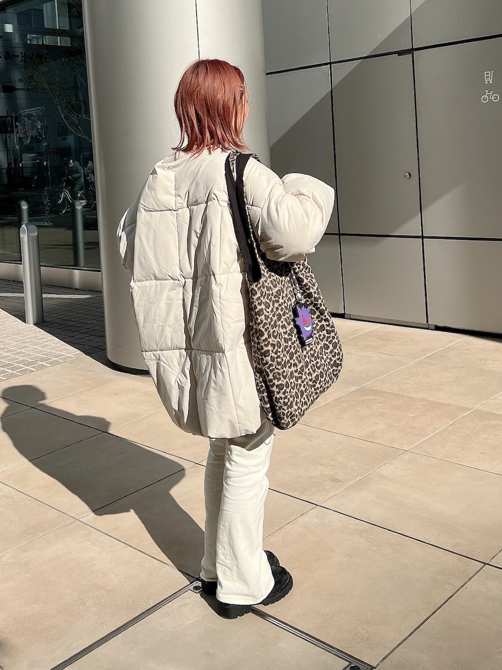 ピンク系のカーディガン/ボレロ、ホワイト系のパンツ、ブラウン系のトートバッグを着用したレディースの冬コーディネートの2枚目の写真