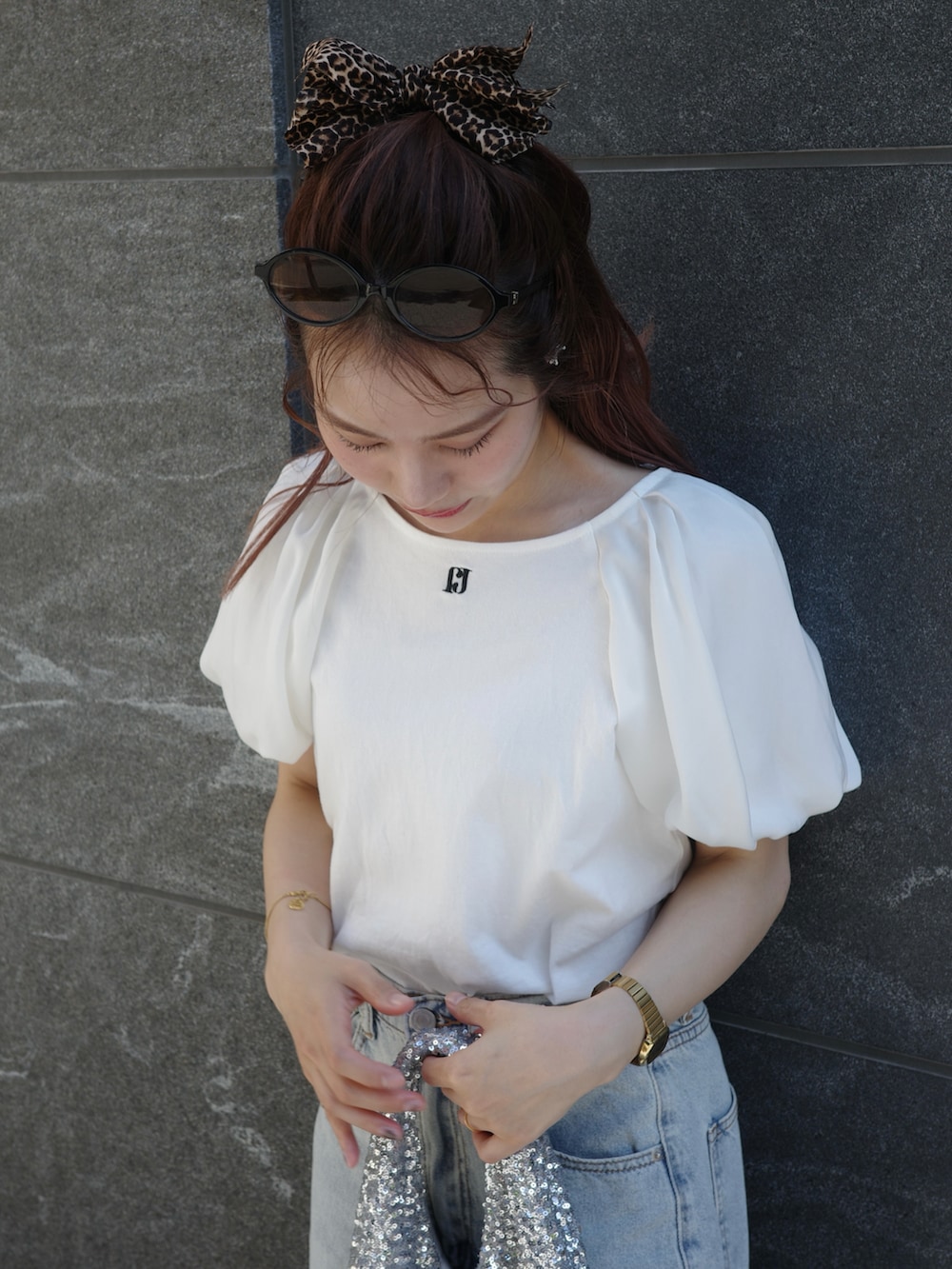 ホワイト系のTシャツ/カットソー、ブルー系のデニムパンツ、ブラウン系のバレッタ/ヘアクリップを着用したレディースの夏コーディネートの3枚目の写真