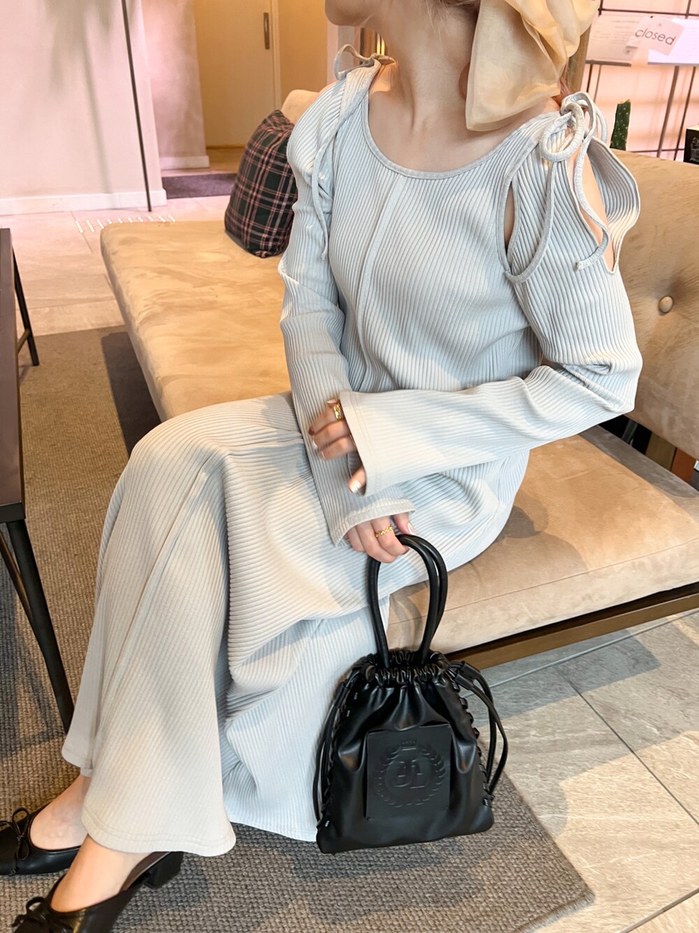 グレー系のワンピース、ブラック系のショルダーバッグ、ブラック系のパンプスを着用したレディースの春コーディネートの2枚目の写真