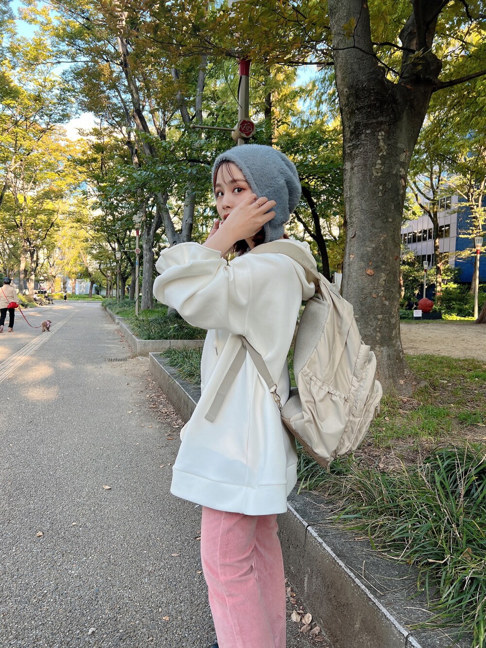 ホワイト系のパーカー、ピンク系のパンツ、ブラック系のブーツを着用したレディースの秋コーディネートの2枚目の写真