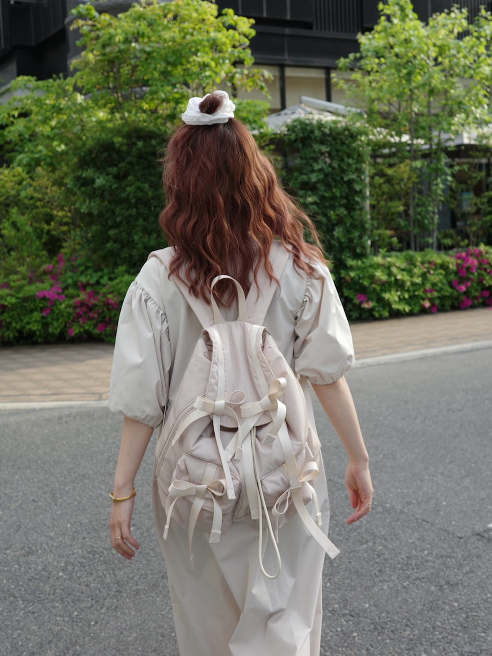 ベージュ系のワンピース、ホワイト系のスニーカー、ベージュ系のバックパック/リュックを着用したレディースの春コーディネートの2枚目の写真