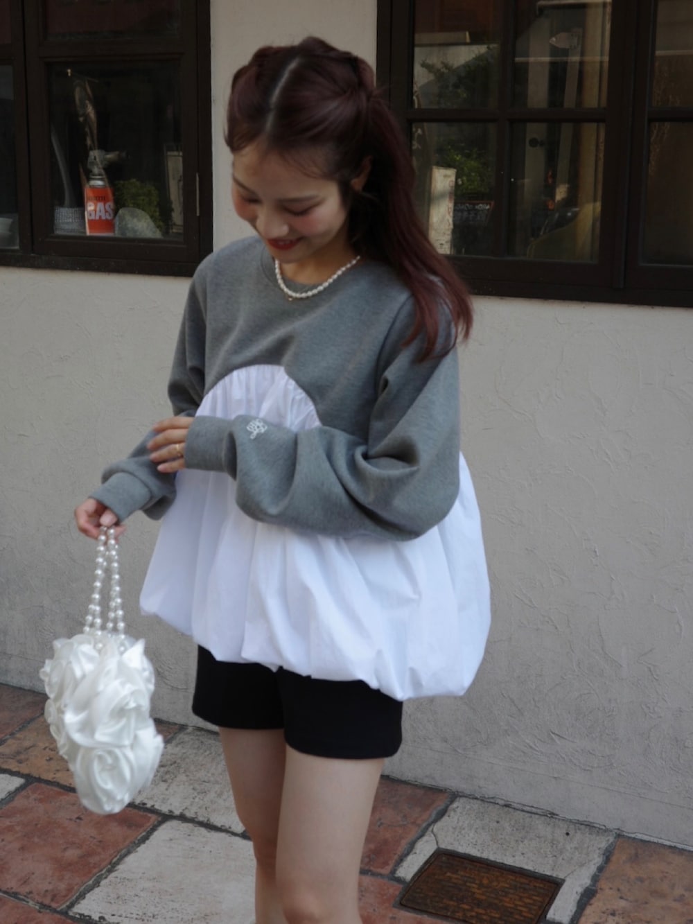 グレー系のTシャツ/カットソー、ブラック系のブーツ、ホワイト系のハンドバッグを着用したレディースの秋コーディネートの2枚目の写真