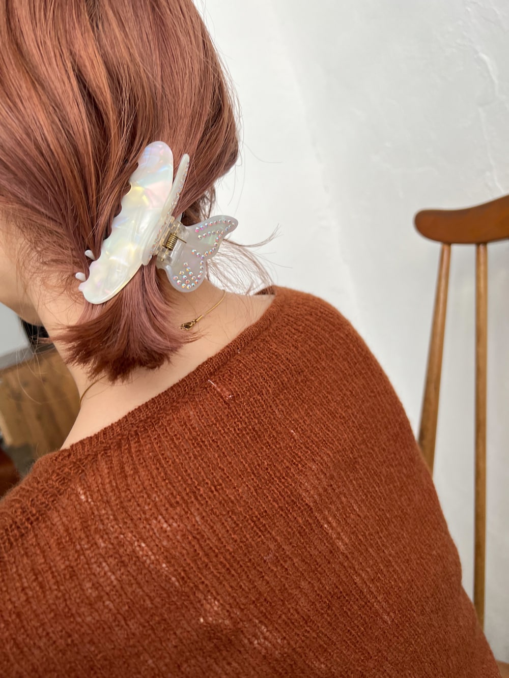 ブラウン系のニット/セーター、ホワイト系のスカート、ホワイト系のブーツを着用したレディースの冬コーディネートの2枚目の写真