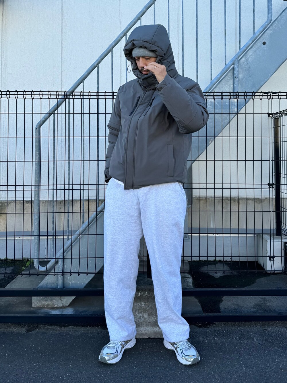 ブラック系のダウンジャケット/コート、グレー系のスウェットパンツ、ホワイト系のスニーカーを着用したメンズの冬コーディネートの2枚目の写真