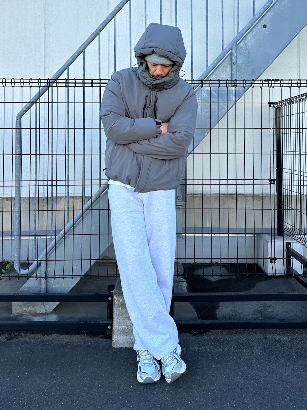 ブラック系のダウンジャケット/コート、グレー系のスウェットパンツ、ホワイト系のスニーカーを着用したメンズの冬コーディネートの5枚目の写真