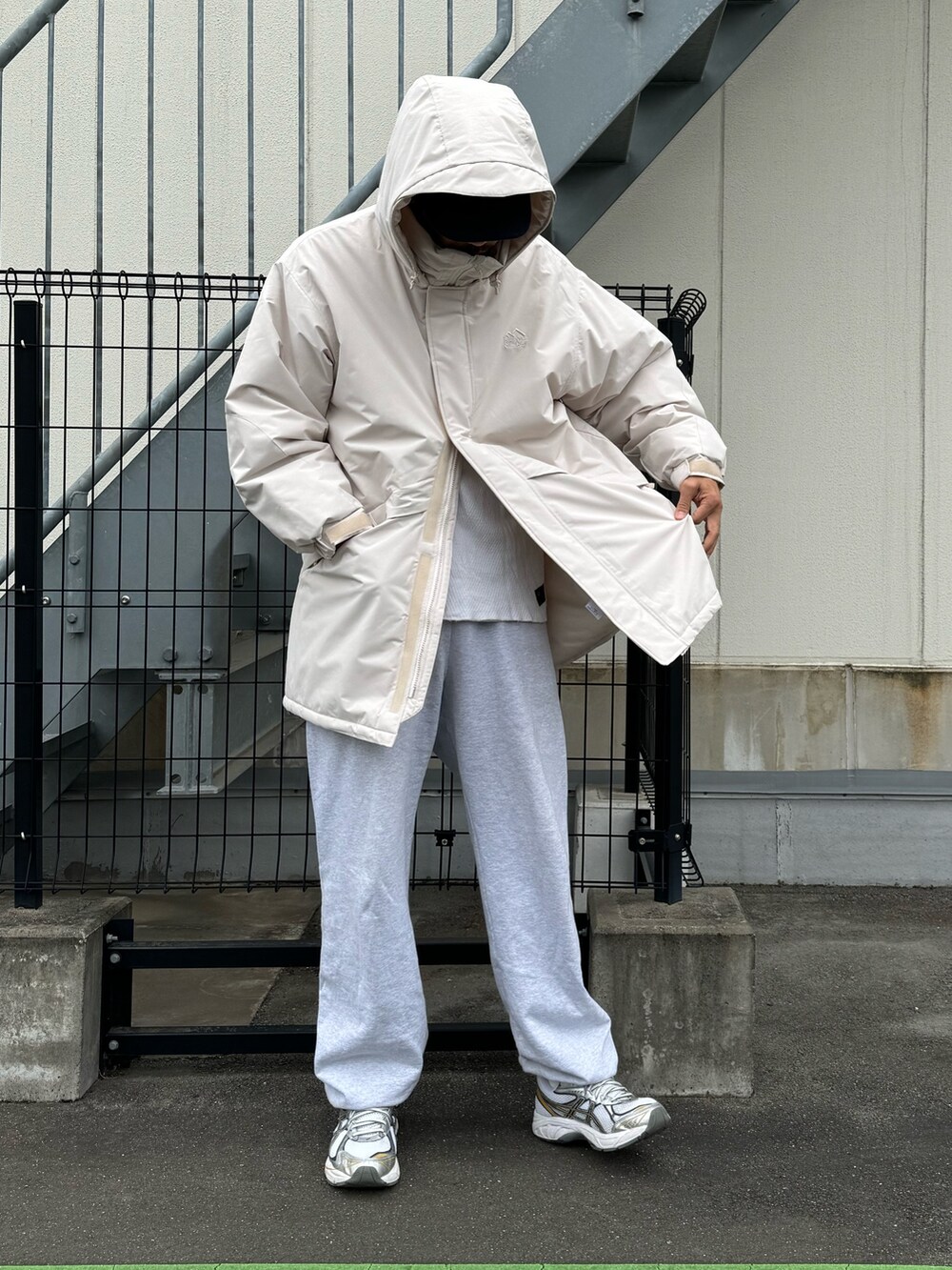 ブラック系のダウンジャケット/コート、グレー系のスウェットパンツ、ホワイト系のスニーカーを着用したメンズの冬コーディネートの5枚目の写真