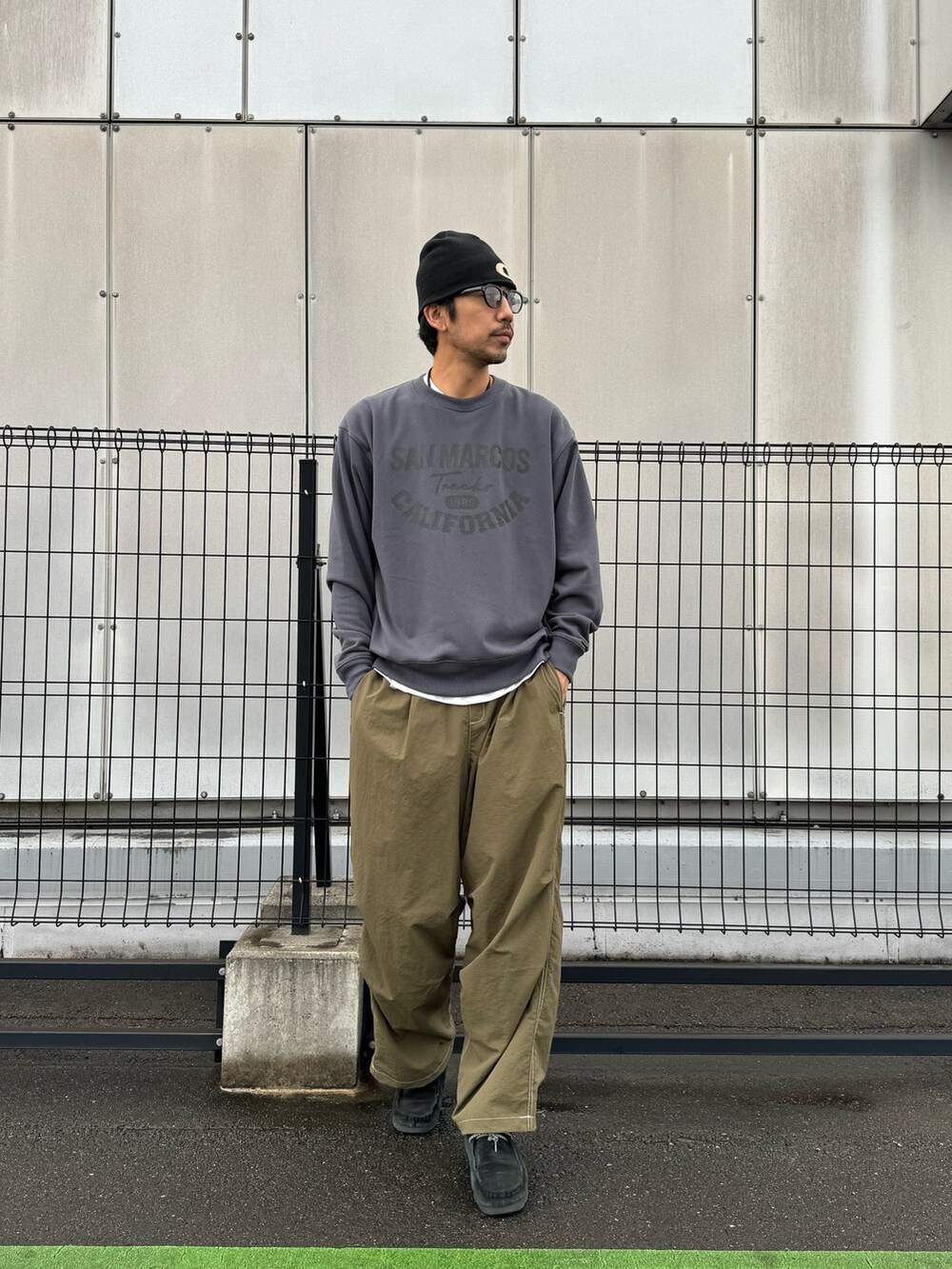 グレー系のスウェット、ブラック系のカーゴパンツ、ブラック系のブーツを着用したメンズの秋コーディネートの3枚目の写真