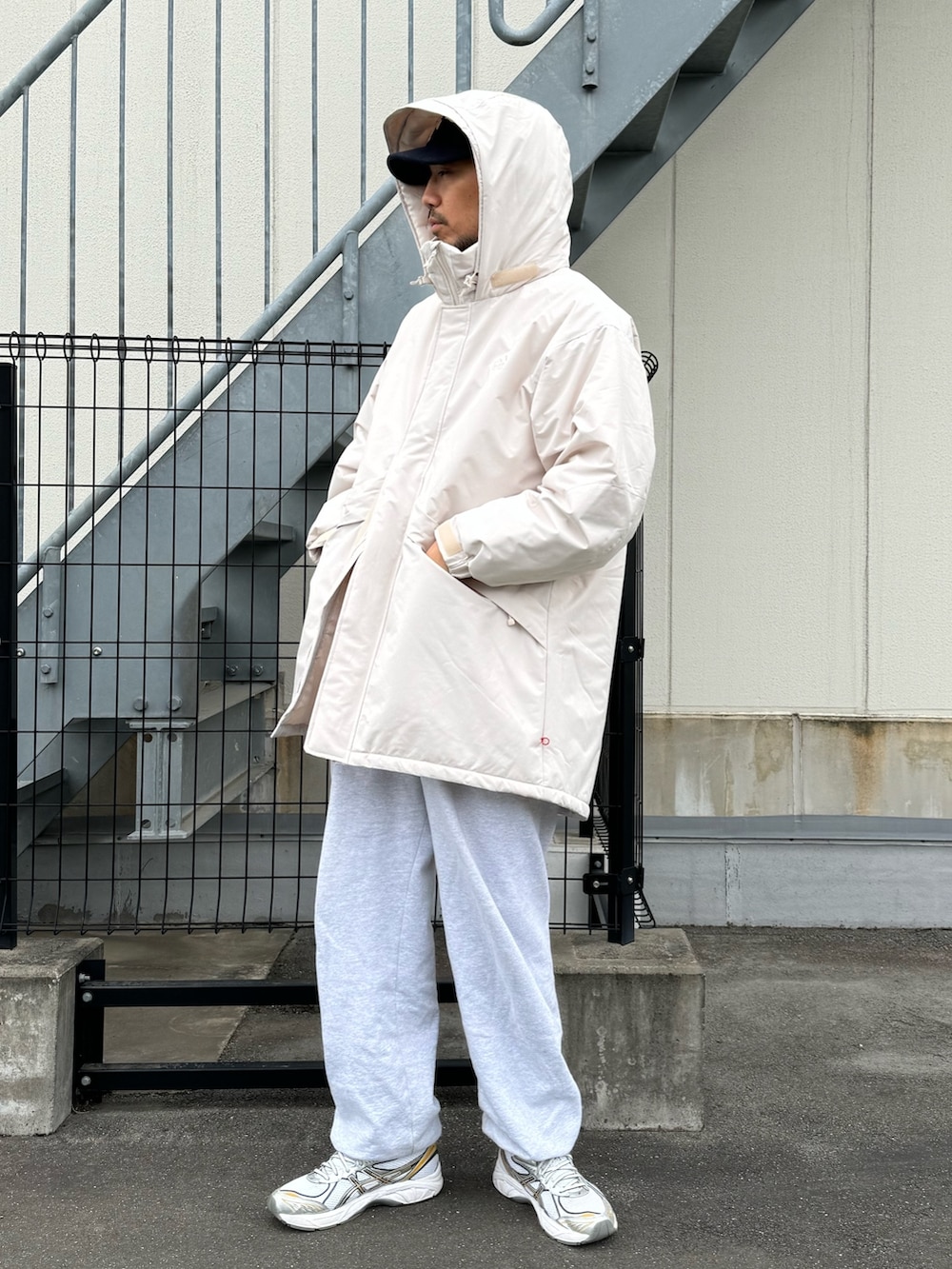 ブラック系のダウンジャケット/コート、グレー系のスウェットパンツ、ホワイト系のスニーカーを着用したメンズの冬コーディネートの7枚目の写真