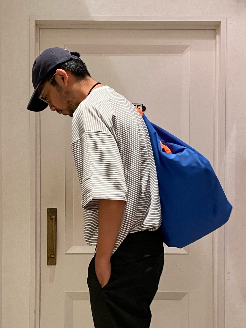 ホワイト系のTシャツ/カットソー、ブルー系のデニムパンツ、ベージュ系のサンダルを着用したメンズの夏コーディネートの3枚目の写真