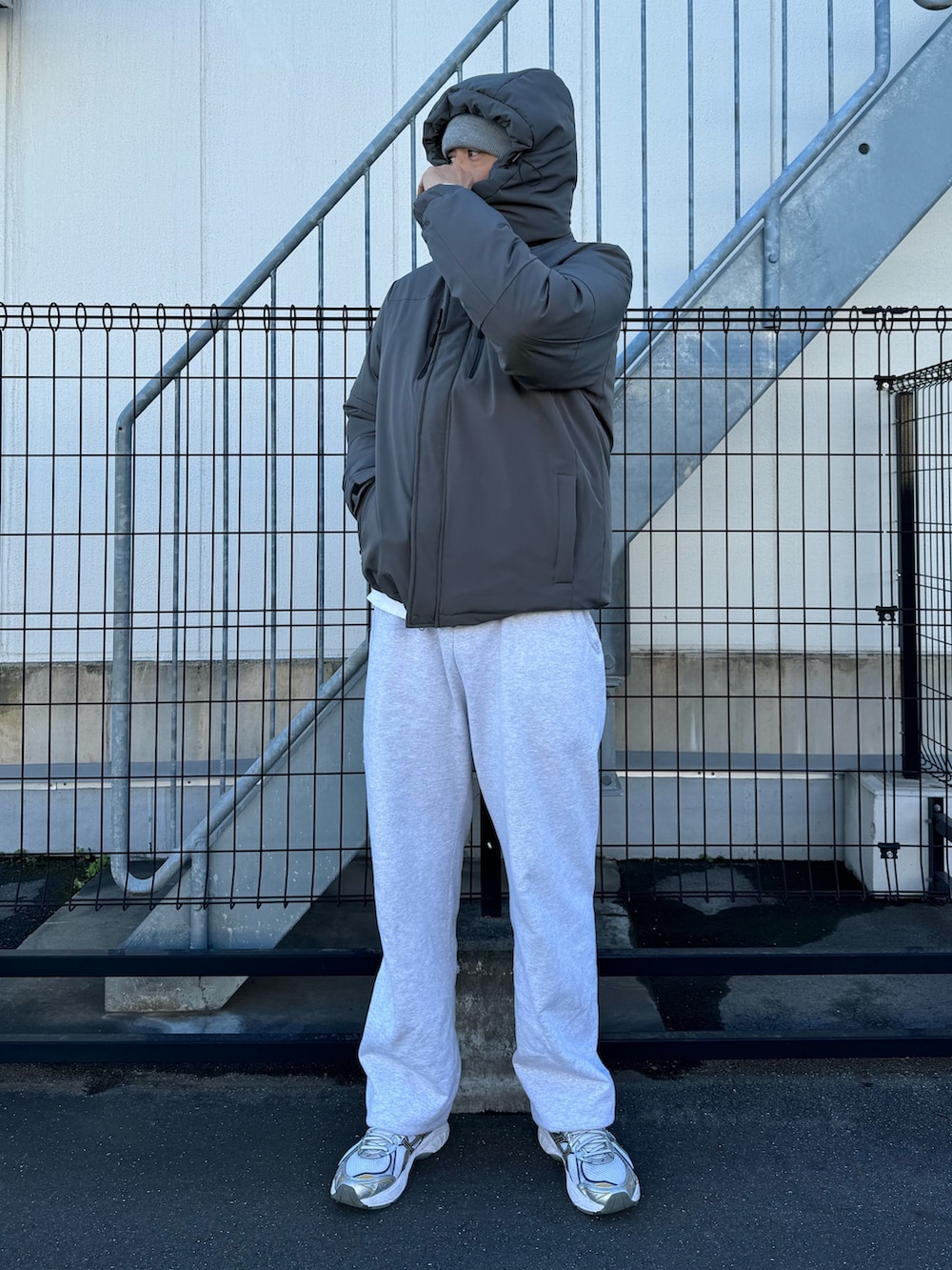 ブラック系のダウンジャケット/コート、グレー系のスウェットパンツ、ホワイト系のスニーカーを着用したメンズの冬コーディネートの6枚目の写真