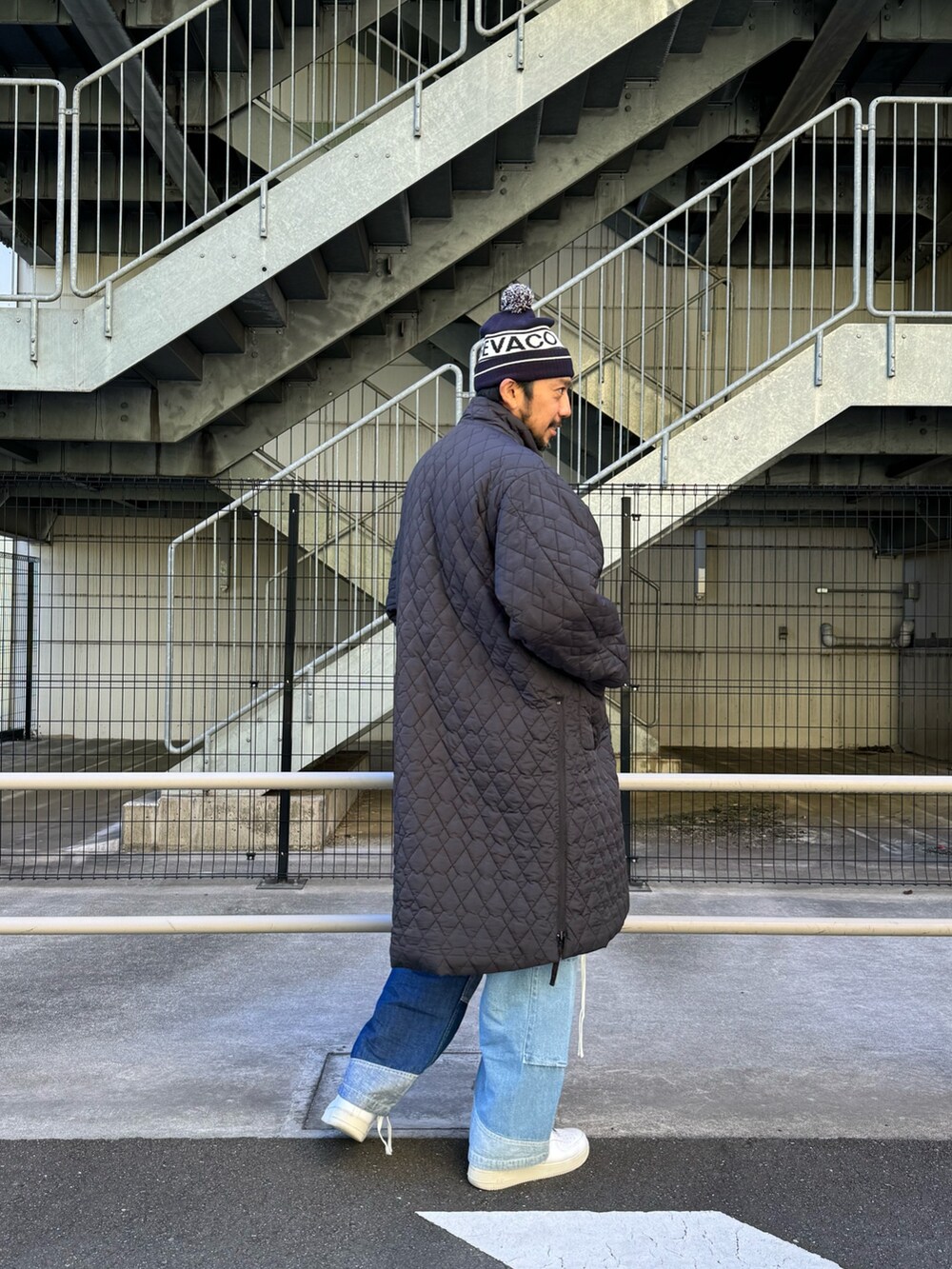 ブラック系のモッズコート、ブルー系のデニムパンツ、ホワイト系のスニーカーを着用したメンズの秋コーディネートの7枚目の写真