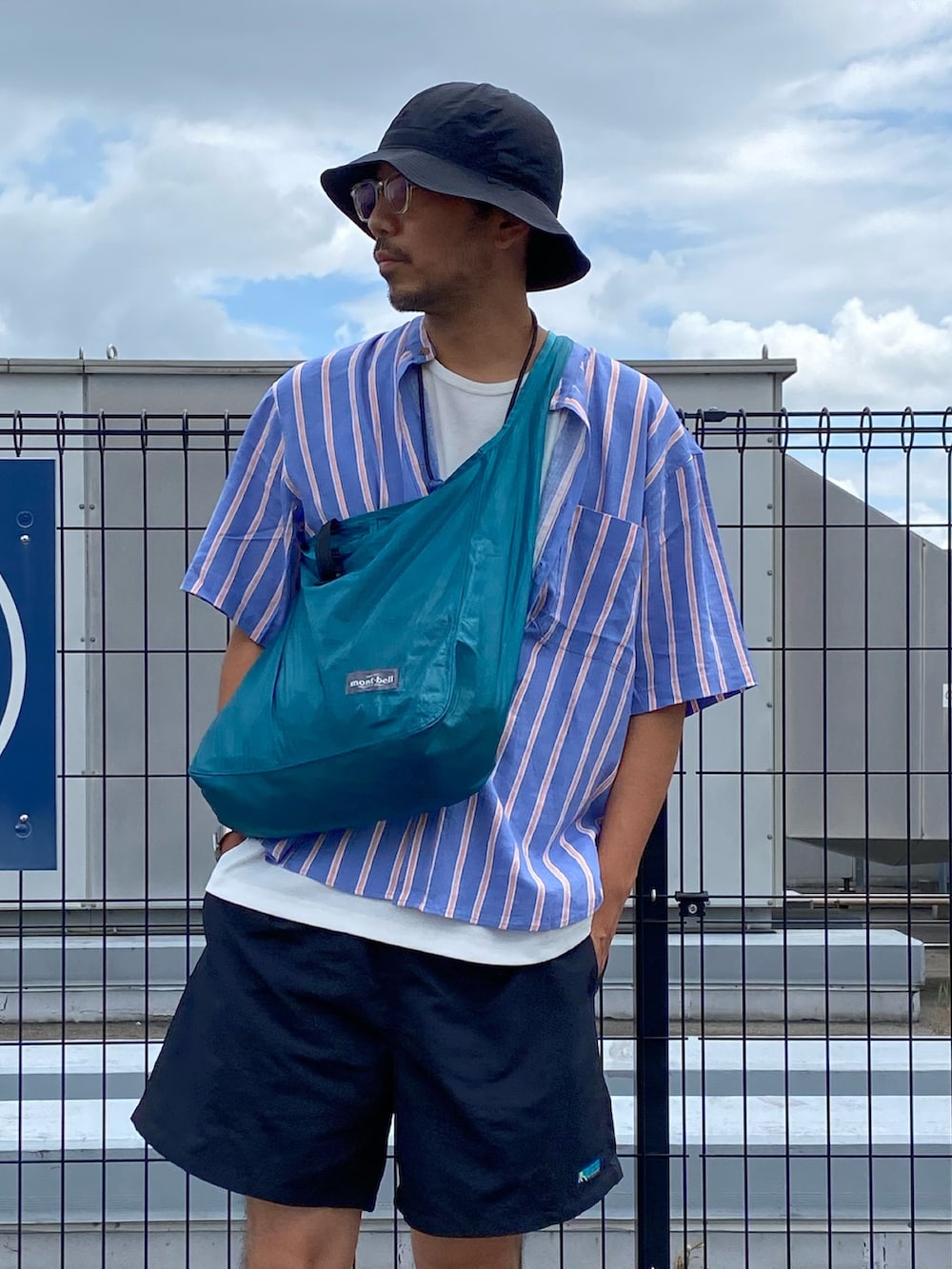 ブルー系のショルダーバッグ、ブルー系のシャツ/ブラウス、ホワイト系のタンクトップを着用したメンズの夏コーディネートの2枚目の写真