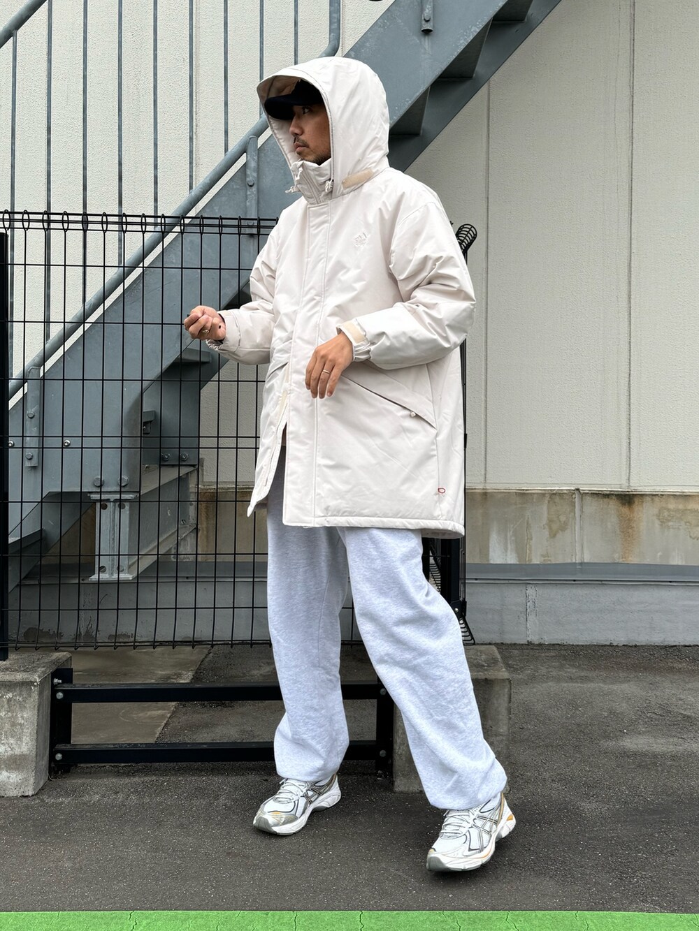 ブラック系のダウンジャケット/コート、グレー系のスウェットパンツ、ホワイト系のスニーカーを着用したメンズの冬コーディネートの4枚目の写真