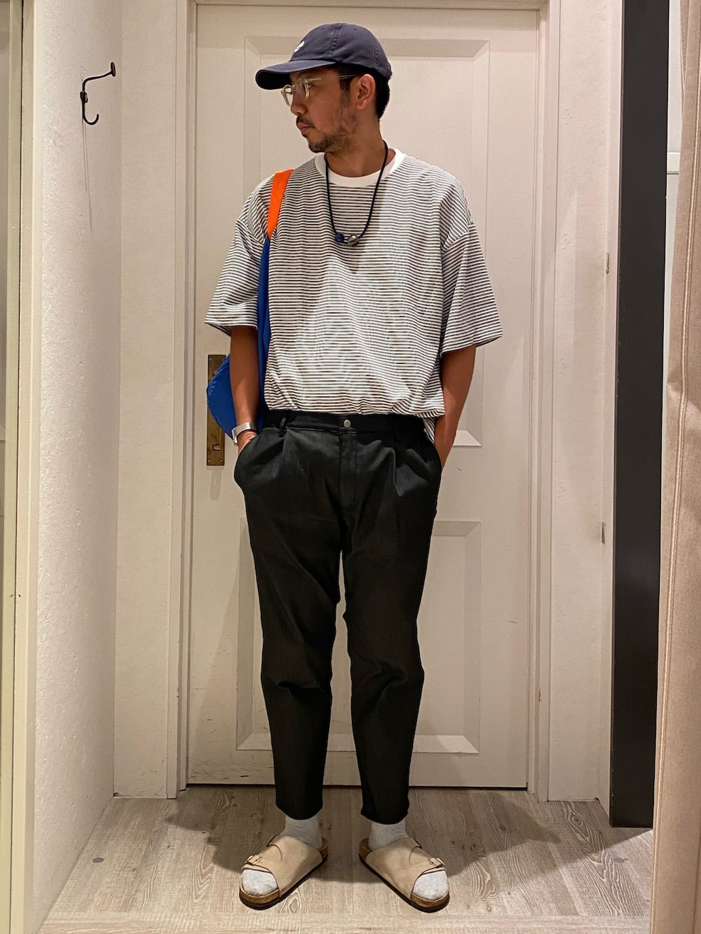 ホワイト系のTシャツ/カットソー、ブルー系のデニムパンツ、ベージュ系のサンダルを着用したメンズの夏コーディネートの2枚目の写真