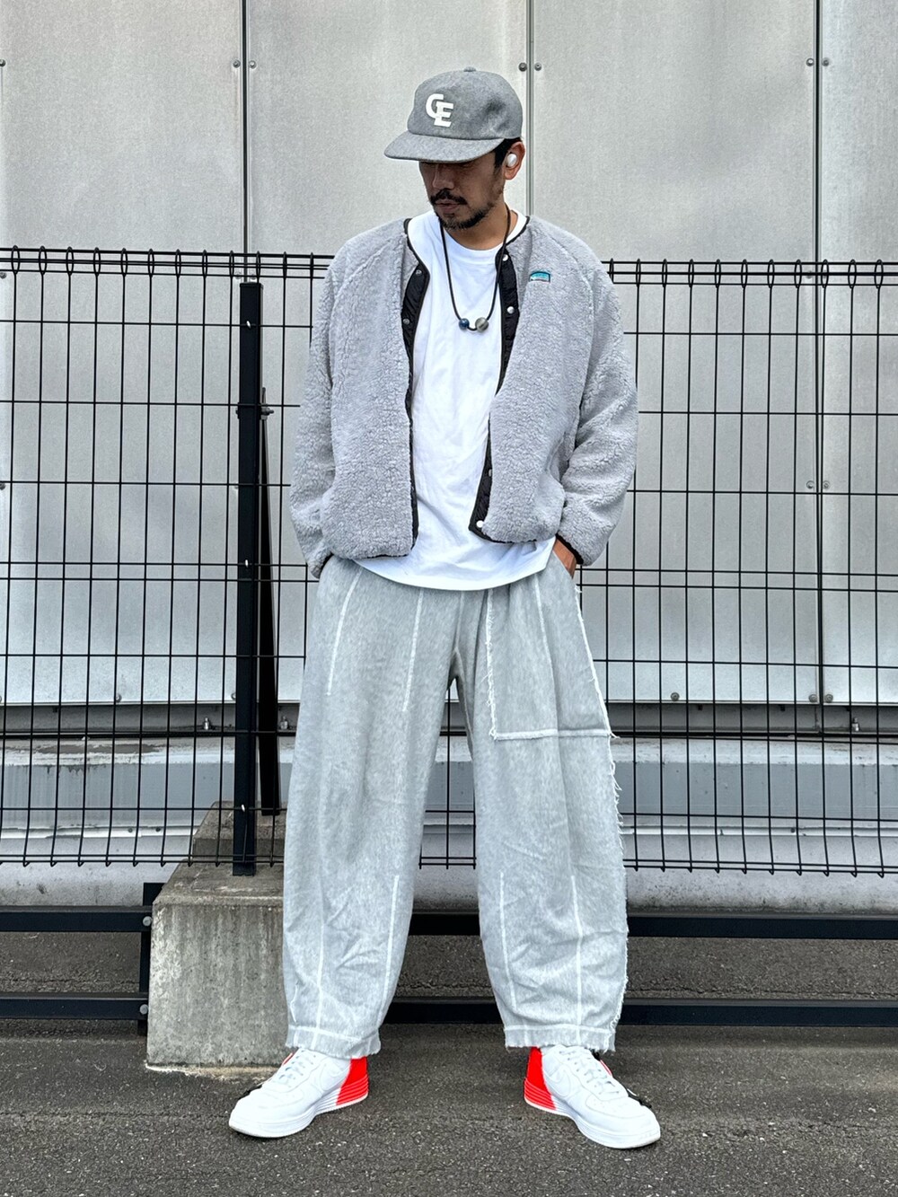 グレー系のブルゾン、ホワイト系のTシャツ/カットソー、グレー系のスウェットパンツを着用したメンズの秋コーディネートの3枚目の写真