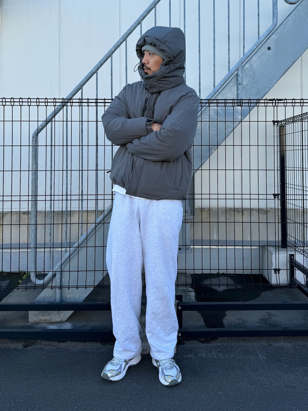 ブラック系のダウンジャケット/コート、グレー系のスウェットパンツ、ホワイト系のスニーカーを着用したメンズの冬コーディネートの3枚目の写真