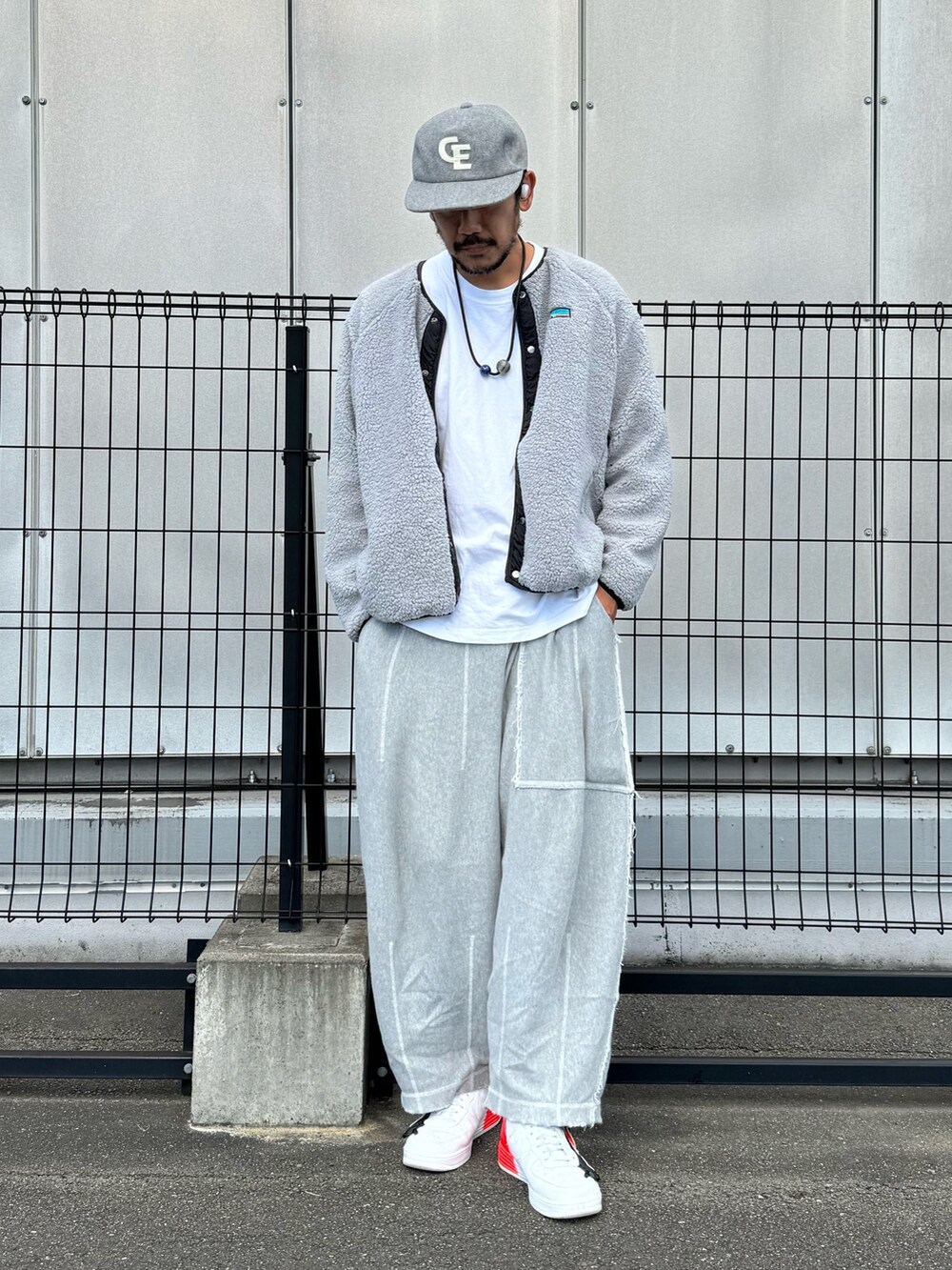 グレー系のブルゾン、ホワイト系のTシャツ/カットソー、グレー系のスウェットパンツを着用したメンズの秋コーディネートの2枚目の写真