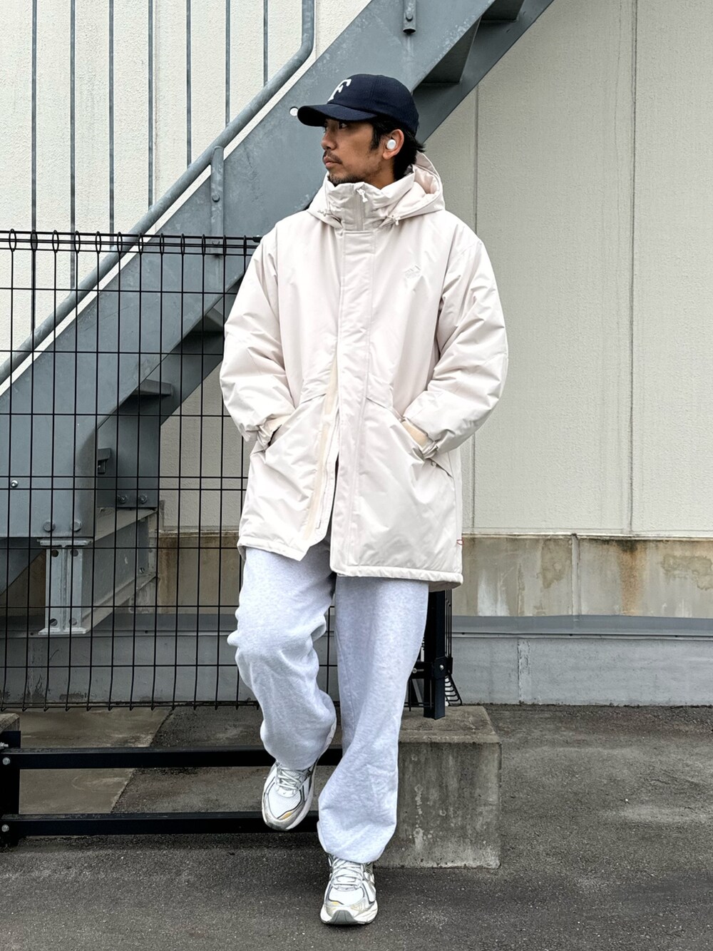 ブラック系のダウンジャケット/コート、グレー系のスウェットパンツ、ホワイト系のスニーカーを着用したメンズの冬コーディネートの2枚目の写真